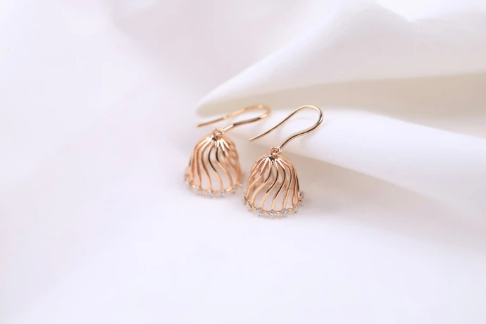 a pair of earrings sitting on top of a white cloth